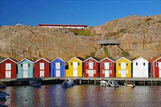 Colourful fishermen's huts nestled against high cliffs, archipelago coast, Smoegen, Vaestra
