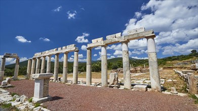 Row of ancient columns under a bright blue sky on an archaeological site, Stoa of the Agora,