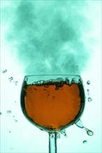 A wine glass with rising bubbles and a smoky, shimmering green atmosphere