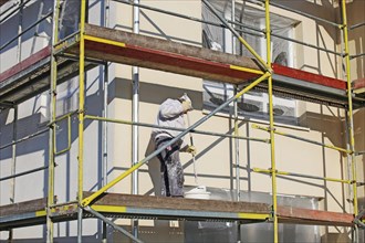 Painter painting the facade of a new residential building (Mutterstadt development area,