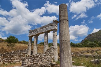 Remains of an ancient temple with columns against a cloudy blue sky, Archaeological site, Ancient