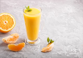 Glass of orange juice on a gray concrete background. Morninig, spring, healthy drink concept. Side