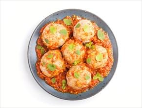 Pork meatballs with tomato sauce, oregano leaves, spices and herbs on blue ceramic plate isolated