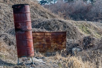 Two rusty metal barrels used as incinerator in rural area in South Korea