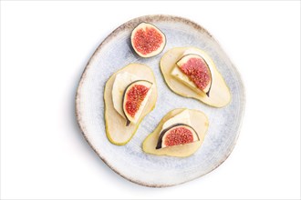 Summer appetizer with pear, cottage cheese, figs and honey on ceramic plate isolated on white