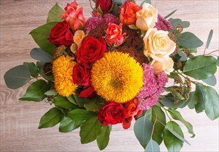 Bouquet of sunflowers and roses on a wooden background. floristic composition
