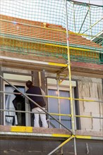 Construction workers insulate a house facade