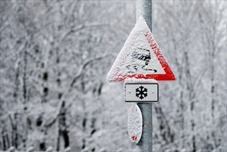 Warning sign danger of skidding, snow covered in winter, Munich, Bavaria, Germany, Europe