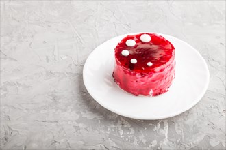 Red cake with souffle cream on a gray concrete background. side view, copy space