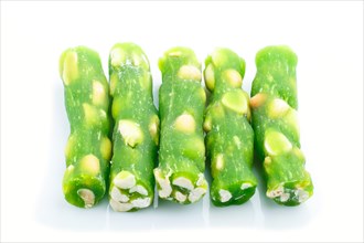 Green traditional turkish delight (rahat lokum) with peanuts isolated on white background. side