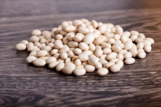 Pile of white beans isolated on a gray wooden background. Closeup