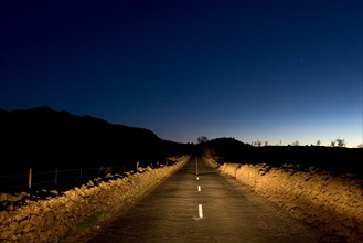 Deserted rural road in the night, headlight of a car, near Los Llanos, La Palma, Canary Islands,
