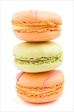 Orange and green macarons or macaroons cakes isolated on white background. side view, close up,