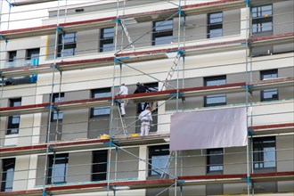 Painter painting the facade of a new apartment building