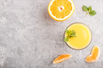 Glass of orange juice on a gray concrete background. Morninig, spring, healthy drink concept. Top