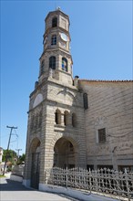 Stone church with tower clock under a clear blue sky, Greek Orthodox Church, Holy Church of Agios