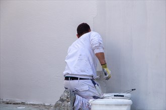 Plasterers plaster the facade of a new building (Mutterstadt development area,