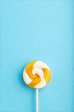 Single lollipop candy on blue pastel background. copy space, top view, flat lay