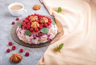 Homemade jelly cake with milk, cookies and raspberry on a gray concrete background with cup of