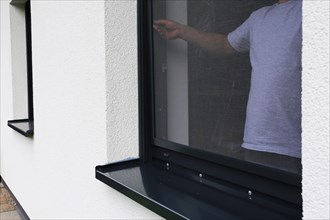 Craftsman installs a fly screen on a window (Limburgerhof, Rhineland-Palatinate)