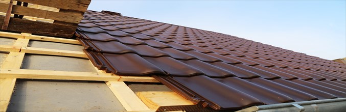 Panoramic image of the roof covering of a new tiled roof on a residential building