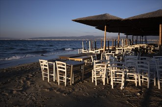 Tables, chairs, stacked, parasols, beach bar, empty, beach, sea, Peraia, also Perea, evening light,