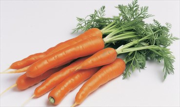 Fresh carrots with green leaves on white background. Close-up AI generated