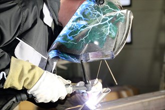 Metalworker during welding work in his workshop