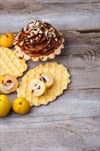 Sweet waffle and cake with cream on a rustic wooden background