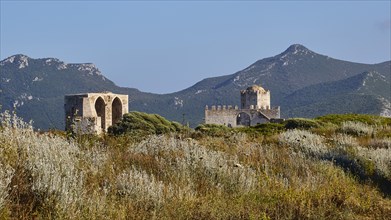 Historic ruin in a rural area with hills and blue sky in the background, sea fortress Methoni,
