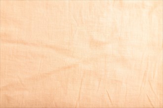 Fragment of smooth orange linen tissue. Top view, flat lay, natural textile background and texture