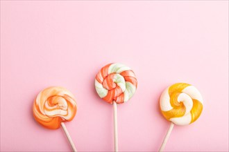 Three lollipop candies on pink pastel background. copy space, top view, flat lay