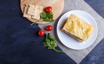 Lasagna with minced meat and cheese on black wooden background. copy space, top view