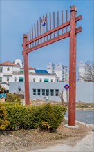 Decorative gate over entrance to Confucian school in Yuseong-gu with city buildings in background
