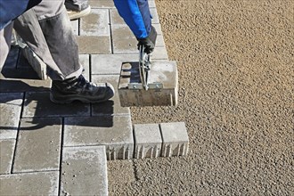 Workers lay paving stones