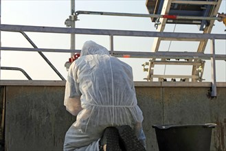 Professional asbestos removal by workers in protective suits
