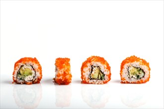 Four Japanese maki sushi rolls in a row with flying fish roe, avocado, and cucumber isolated on