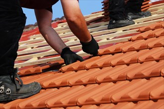 Roofer covering a heritage-protected tiled roof