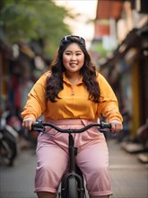 Asian young woman in a yellow sweatshirt casually rides a bike on a city street during the day, San