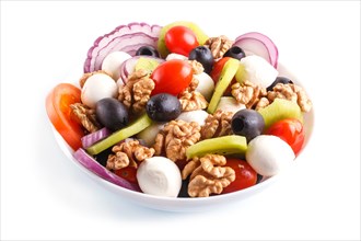 Salad with cherry tomatoes, mozzarella cheese, black olives, kiwi, and walnuts isolated on white