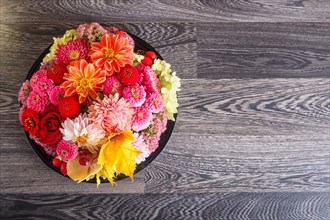 Floral arrangement of autumn flowers on a plate. dahlia, zinnia, rose, orchid, maple leaves. copy