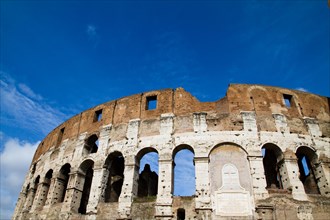 The Colosseum in Rome under a clear blue sky, a symbol of ancient Roman architecture and culture