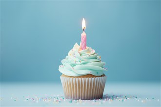 Single cupcake with frosting, sugar sprinkles and birthday candle on blue background. KI generiert,