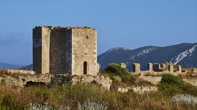 Ruins of an ancient fortress, surrounded by green vegetation and mountains, sea fortress Methoni,