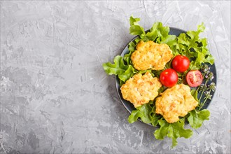 Minced chicken cutlets with lettuce, tomatoes and herbs on a gray concrete background. top view,
