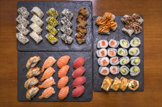 A selection of various sushi including rolls and nigiri on two slate serving platters, Majorca,
