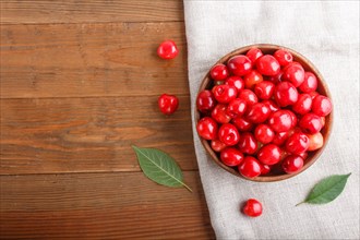 Fresh red sweet cherry in wooden bowl on wooden background. top view, flat lay, copy space