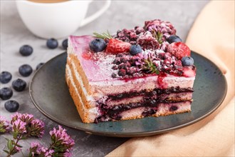 Berry cake with milk cream and blueberry jam on blue ceramic plate with cup of coffee and fresh