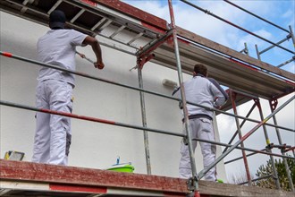 Painter painting the facade of a new residential building
