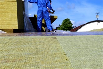 Employees of Uwe Adrian Bauspenglerei GmbH from Worms insulate the roof of a multi-purpose hall in